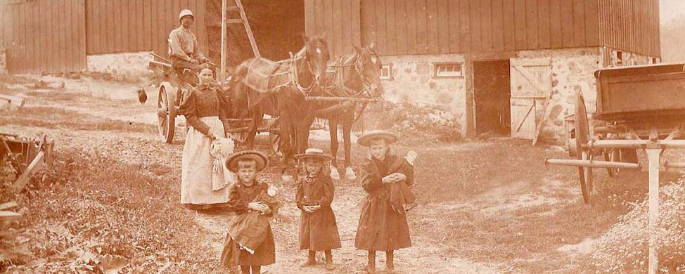 family in front of barn, circa 1900